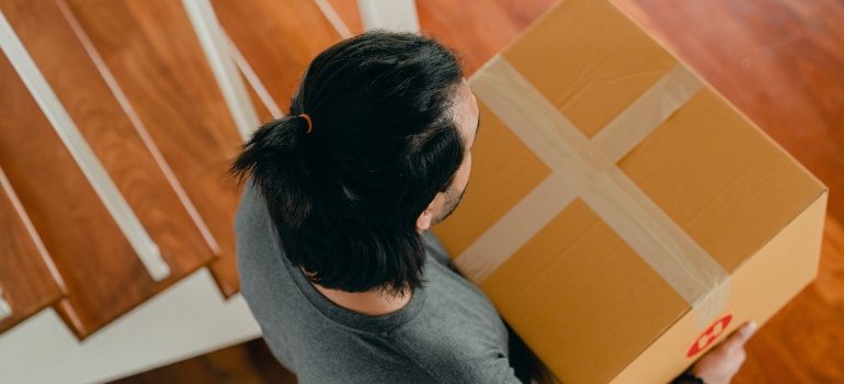 3 16 man carrying the box down the stairs